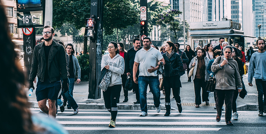 Large crowd of people walking across the street